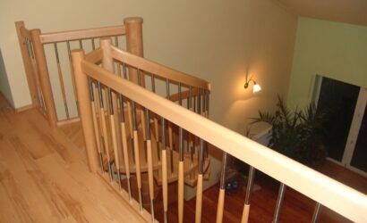 Drewniane schody kręte z metalowymi balustradami