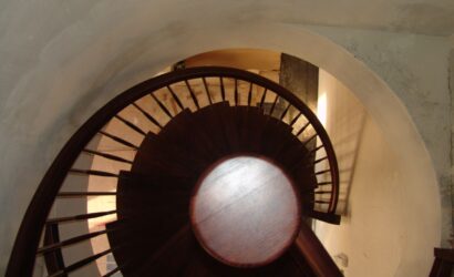 Drewniane schody kręte z metalowymi balustradami