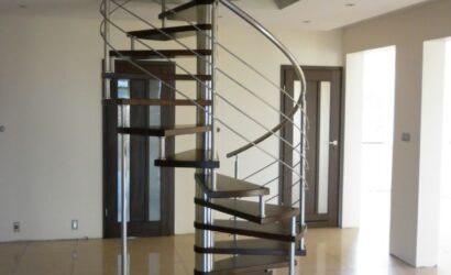 Drewniane schody kręte z metalowymi balustradami