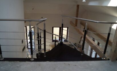 Drewniane schody kręte z metalowymi balustradami
