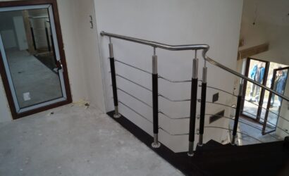 Drewniane schody kręte z metalowymi balustradami
