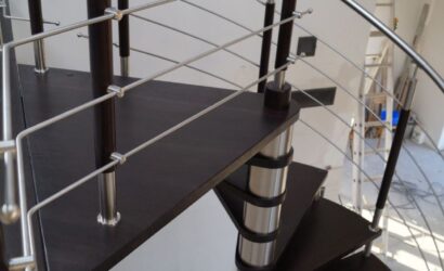Drewniane schody kręte z metalowymi balustradami