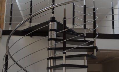 Drewniane schody kręte z metalowymi balustradami