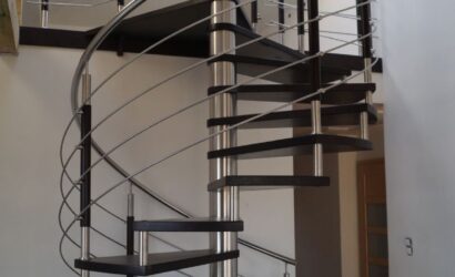 Drewniane schody kręte z metalowymi balustradami