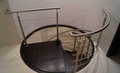 Drewniane schody kręte z metalowymi balustradami