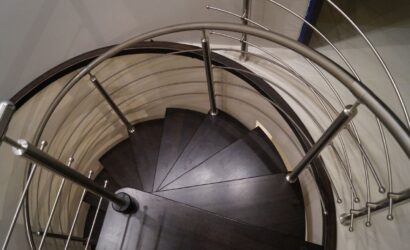 Drewniane schody kręte z metalowymi balustradami
