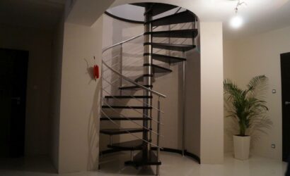 Drewniane schody kręte z metalowymi balustradami