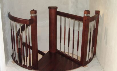 Drewniane schody kręte z metalowymi balustradami