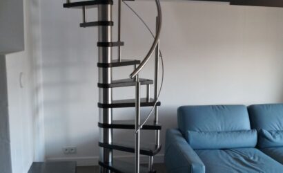 Drewniane schody kręte z metalowymi balustradami