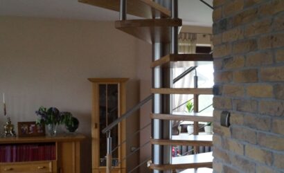 Drewniane schody kręte z metalowymi balustradami