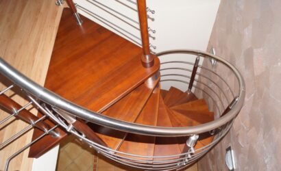 Drewniane schody kręte z metalowymi balustradami
