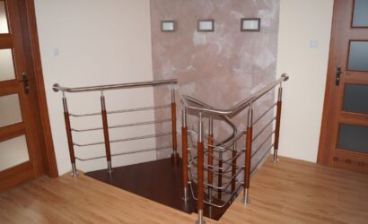 Drewniane schody kręte z metalowymi balustradami
