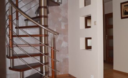 Drewniane schody kręte z metalowymi balustradami