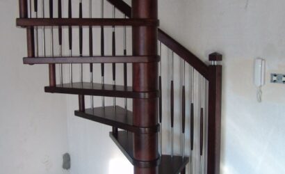 Drewniane schody kręte z metalowymi balustradami