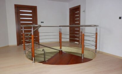 Drewniane schody kręte z metalowymi balustradami