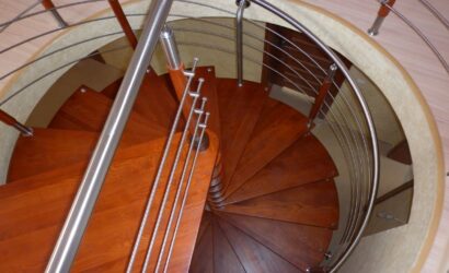 Drewniane schody kręte z metalowymi balustradami