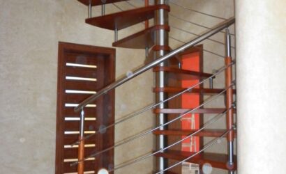 Drewniane schody kręte z metalowymi balustradami
