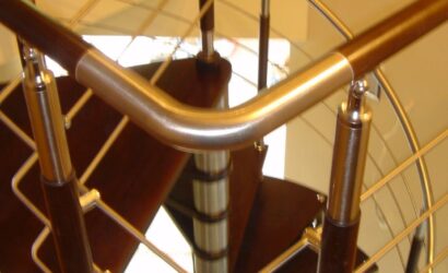 Drewniane schody kręte z metalowymi balustradami