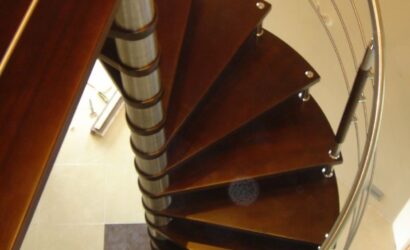 Drewniane schody kręte z metalowymi balustradami