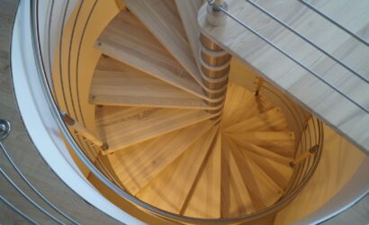 Drewniane schody kręte z metalowymi balustradami