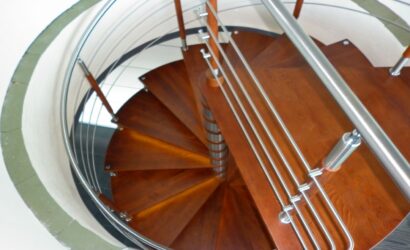 Drewniane schody kręte z metalowymi balustradami