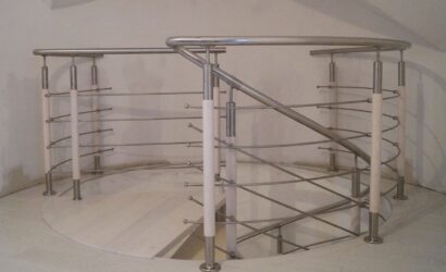 Drewniane schody kręte z metalowymi balustradami