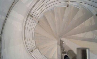 Drewniane schody kręte z metalowymi balustradami