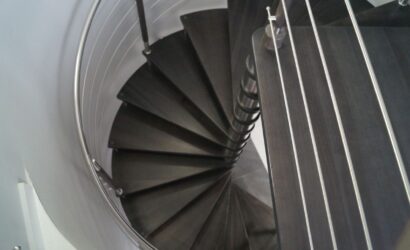 Drewniane schody kręte z metalowymi balustradami