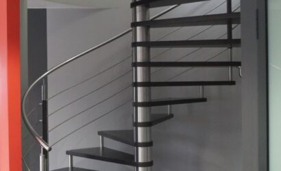 Drewniane schody kręte z metalowymi balustradami
