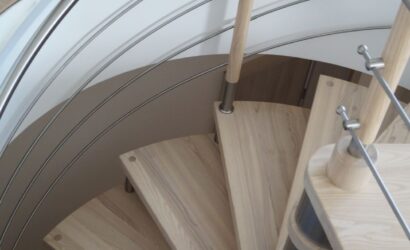 Drewniane schody kręte z metalowymi balustradami