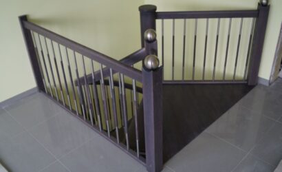 Drewniane schody kręte z metalowymi balustradami