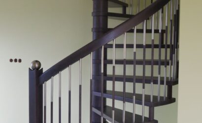 Drewniane schody kręte z metalowymi balustradami