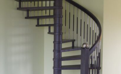 Drewniane schody kręte z metalowymi balustradami