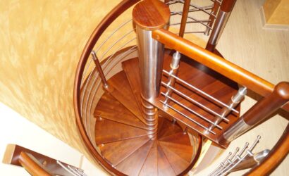 Drewniane schody kręte z metalowymi balustradami