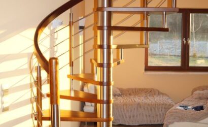 Drewniane schody kręte z metalowymi balustradami