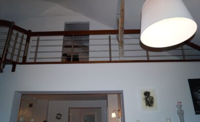 Drewniane schody kręte z metalowymi balustradami