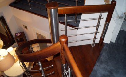 Drewniane schody kręte z metalowymi balustradami