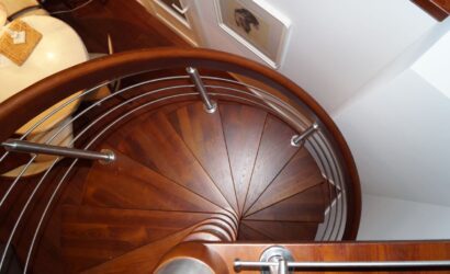 Drewniane schody kręte z metalowymi balustradami
