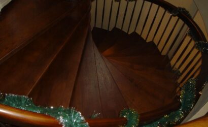 Drewniane schody kręte z metalowymi balustradami