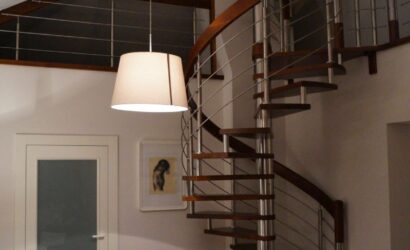 Drewniane schody kręte z metalowymi balustradami
