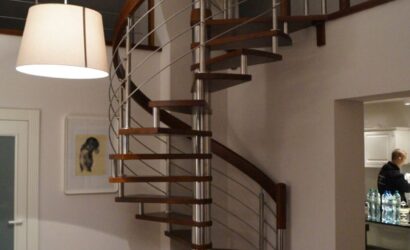Drewniane schody kręte z metalowymi balustradami