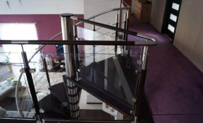 Drewniane schody kręte z metalowymi balustradami