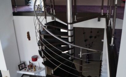 Drewniane schody kręte z metalowymi balustradami