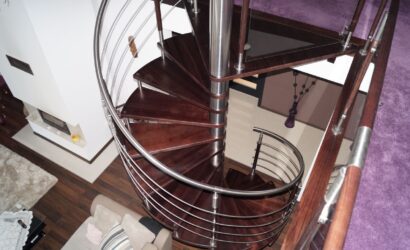 Drewniane schody kręte z metalowymi balustradami