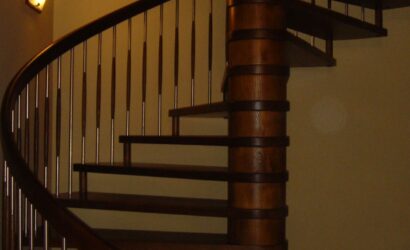 Drewniane schody kręte z metalowymi balustradami
