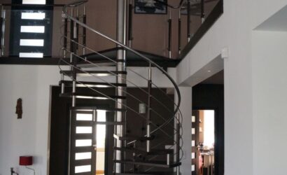 Drewniane schody kręte z metalowymi balustradami