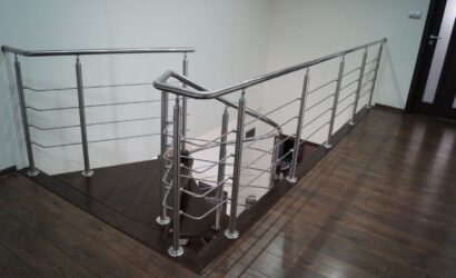 Drewniane schody kręte z metalowymi balustradami