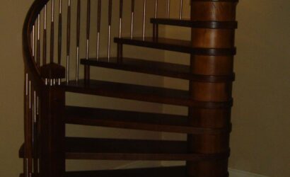 Drewniane schody kręte z metalowymi balustradami