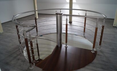 Drewniane schody kręte z metalowymi balustradami