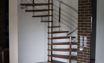 Drewniane schody kręte z metalowymi balustradami